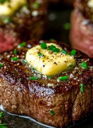 Pan seared steak topped with garlic butter on a plate