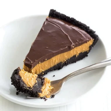 No bake chocolate peanut butter pie topped with chocolate drizzle and peanuts