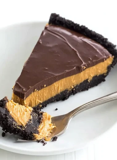 No bake chocolate peanut butter pie topped with chocolate drizzle and peanuts