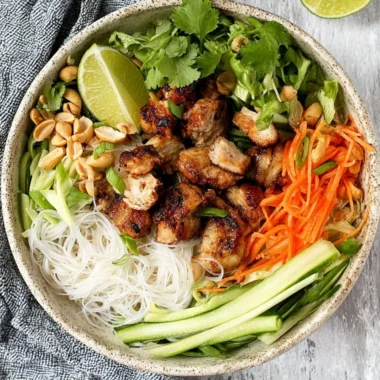 Vietnamese noodle bowl featuring lemongrass chicken and vibrant vegetables