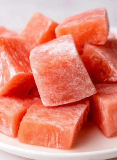 Delicious watermelon mochi with vibrant pink filling and white rice exterior.